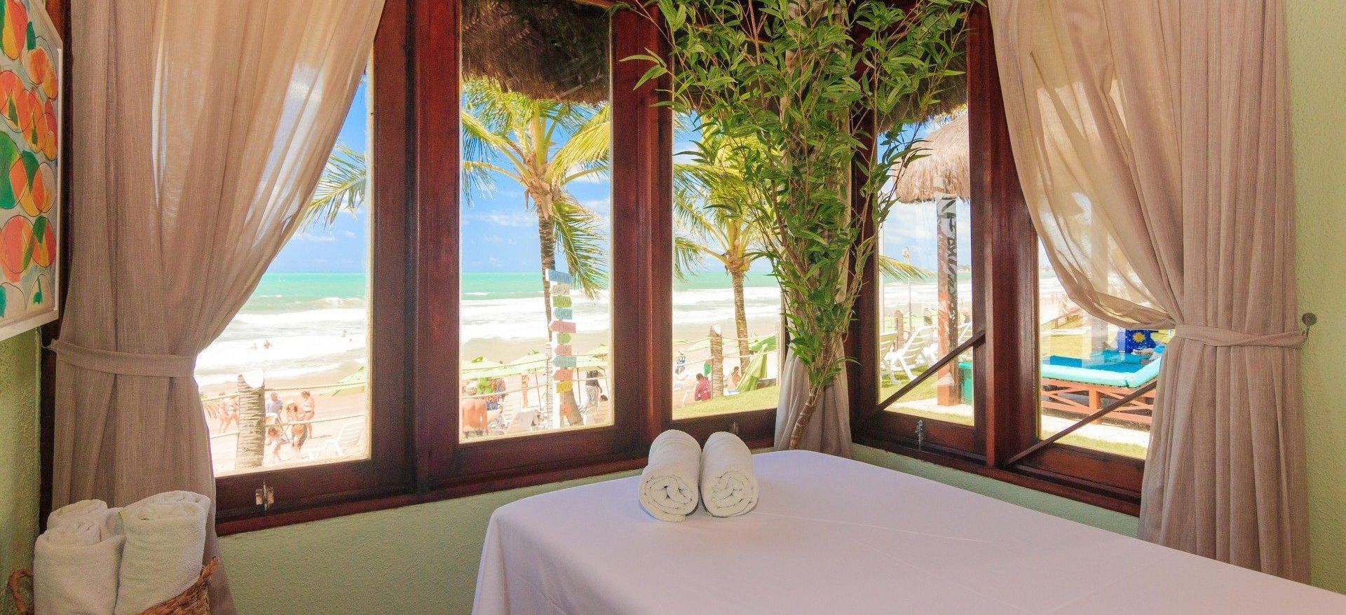 Uma mesa de massagem em uma sala com vista para a praia.