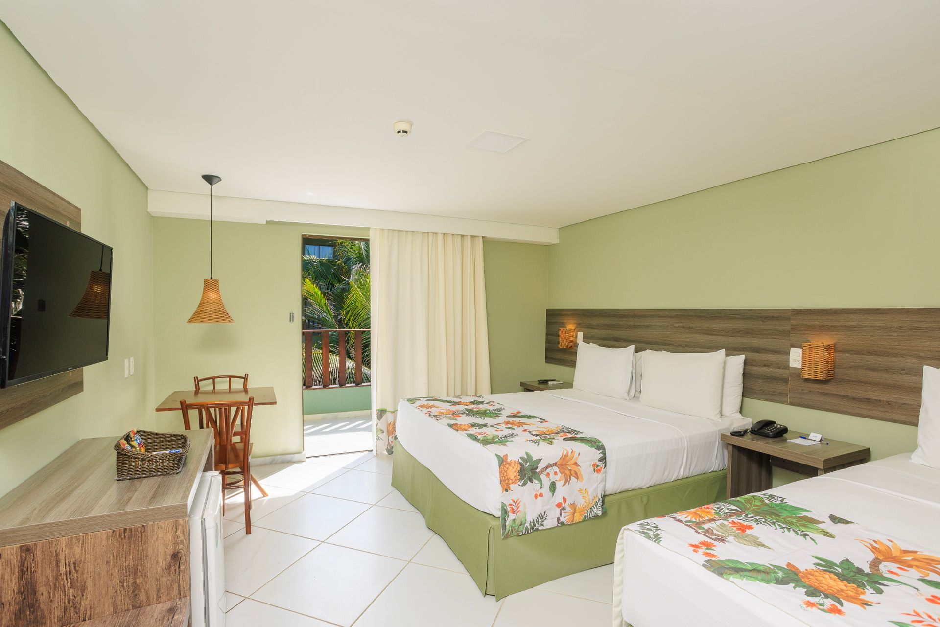 Um quarto de hotel com duas camas e uma TV de tela plana.