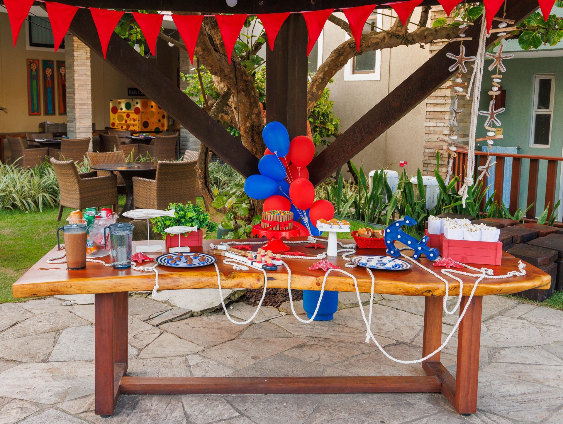 Uma mesa de madeira com pratos e balões é decorada para uma festa de aniversário.