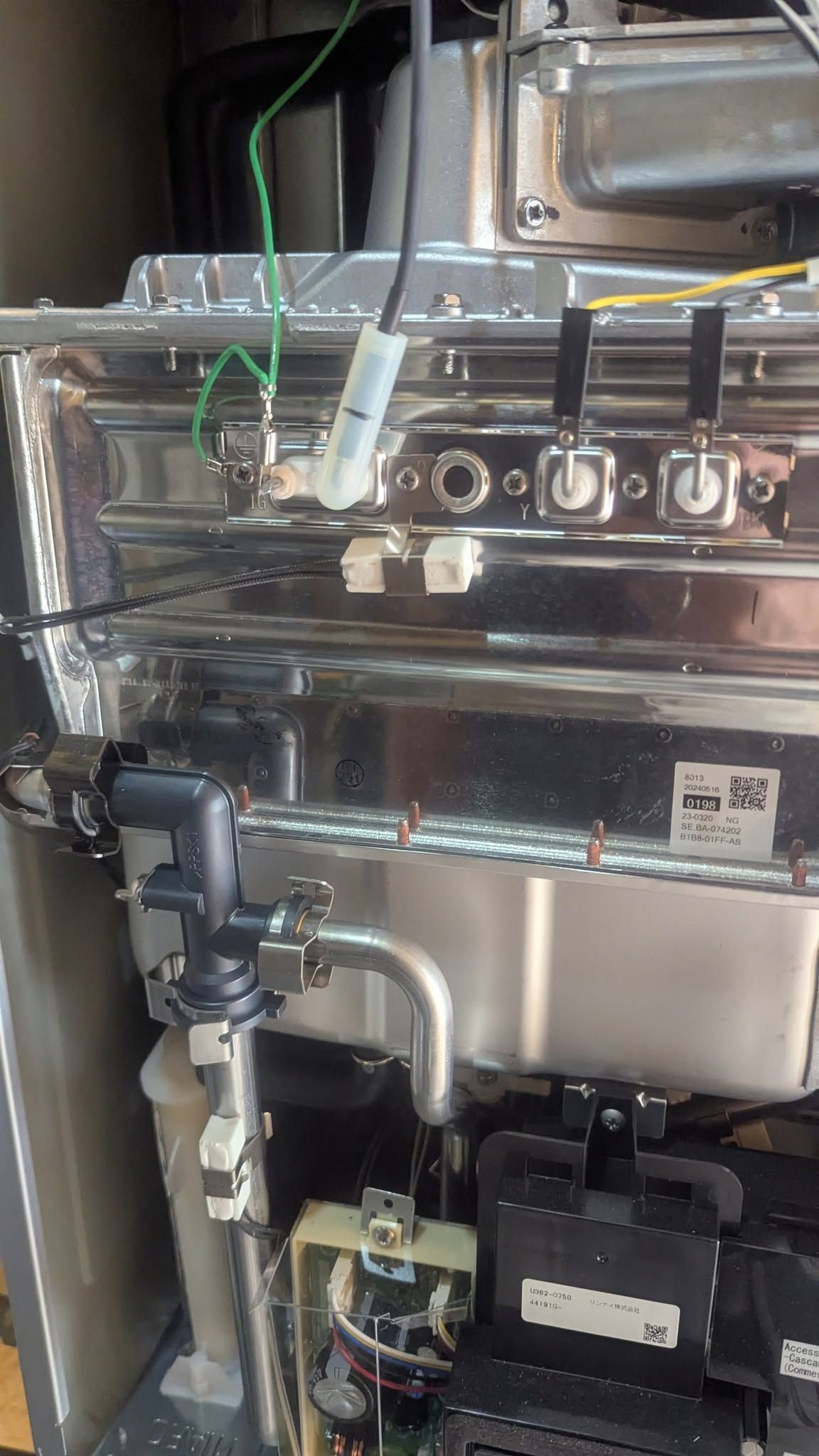 Industrial machine interior with pipes, wires, and control components in a metal enclosure