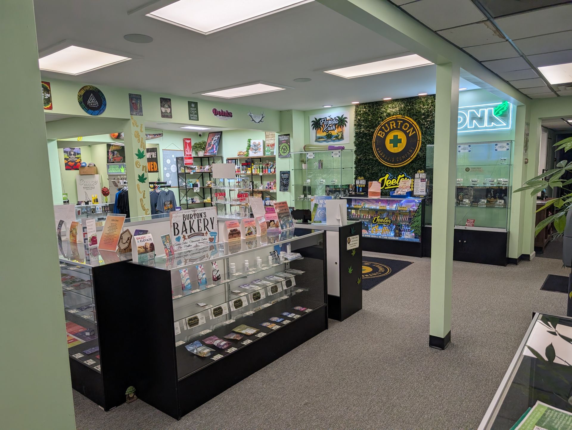 Inside a cannabis dispensary with display cases, products, and signage.