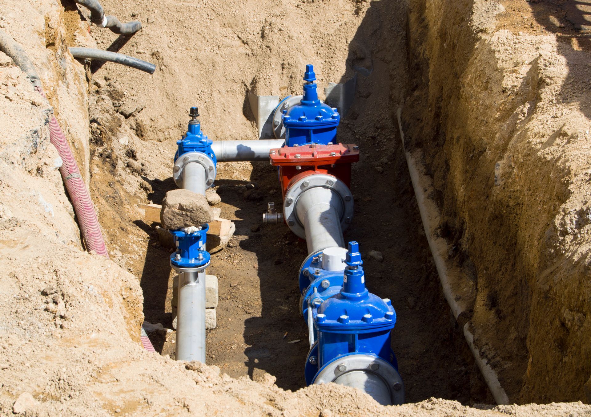 A Bunch of Pipes Are Laying in The Dirt in A Trench | Neenah, WI | Ogden Plumbing