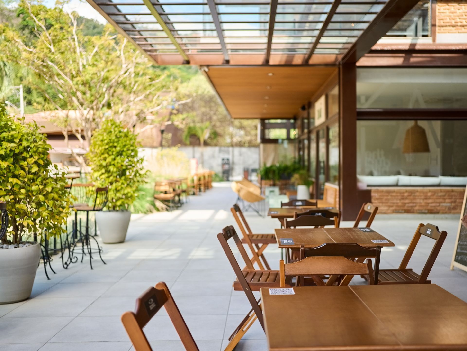A Restaurant with Wooden Tables and Chairs Under a Glass Roof | Neenah, WI | Ogden Plumbing