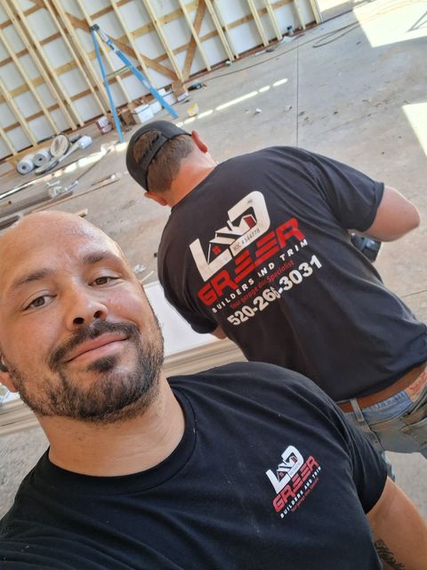 Two men are standing next to each other wearing black shirts.
