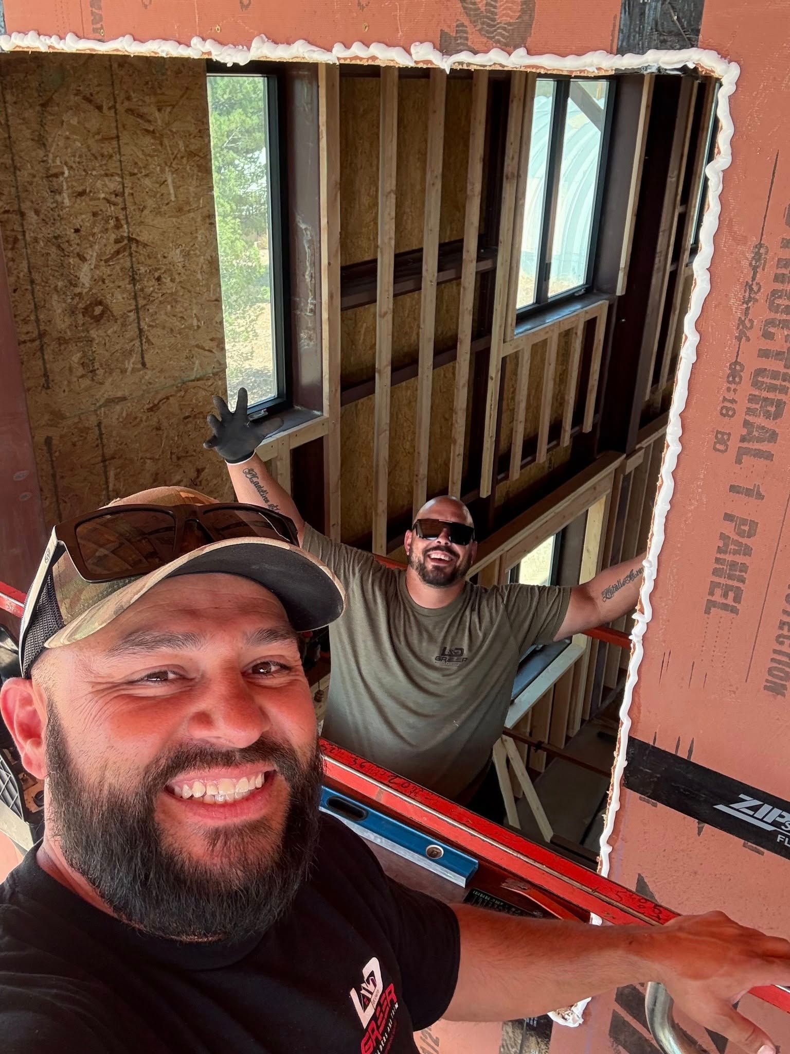 Two men are standing next to each other in a building under construction.