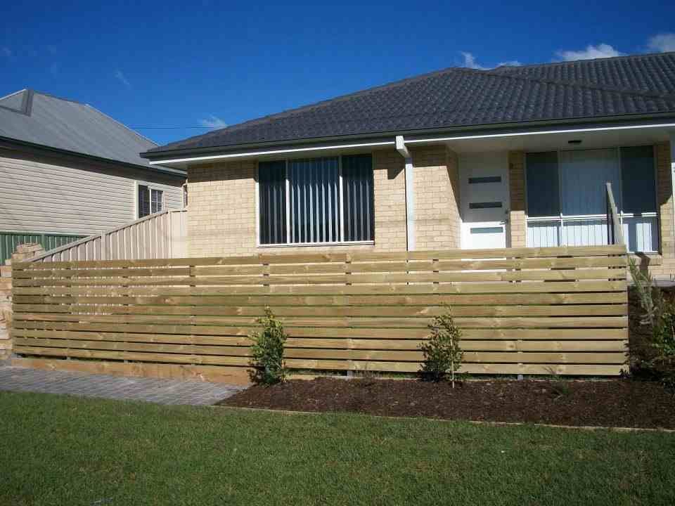 A House with A Wooden Fence in Front of It — Rearden Fencing Pty Ltd in Toronto, NSW