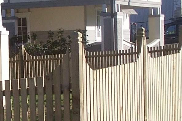 A Wooden Fence with A House in The Background — Rearden Fencing Pty Ltd in Toronto, NSW
