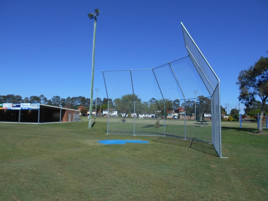 A Baseball Field with A Fence and A Building in The Background — Rearden Fencing Pty Ltd in Rutherford, NSW