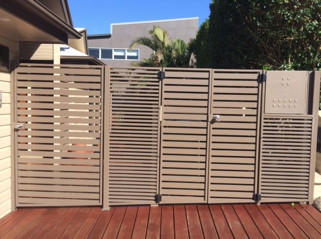 A Wooden Deck With a Fence and a Gate in Front of a House — Rearden Fencing Pty Ltd in Toronto, NSW