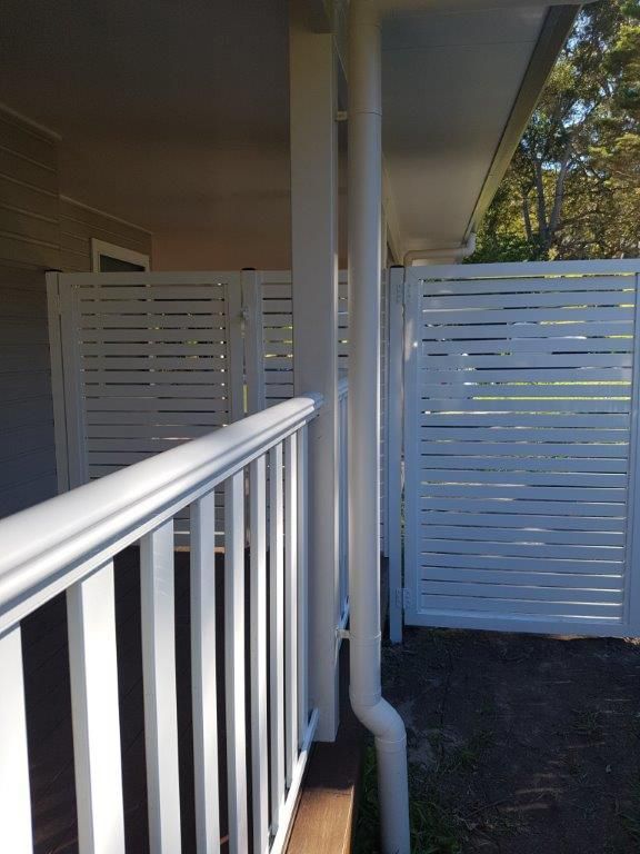 A White Railing on a Porch Next to a White Fence — Rearden Fencing Pty Ltd in Toronto, NSW