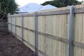 A Wooden Fence With Metal Posts in a Backyard — Rearden Fencing Pty Ltd in Toronto, NSW