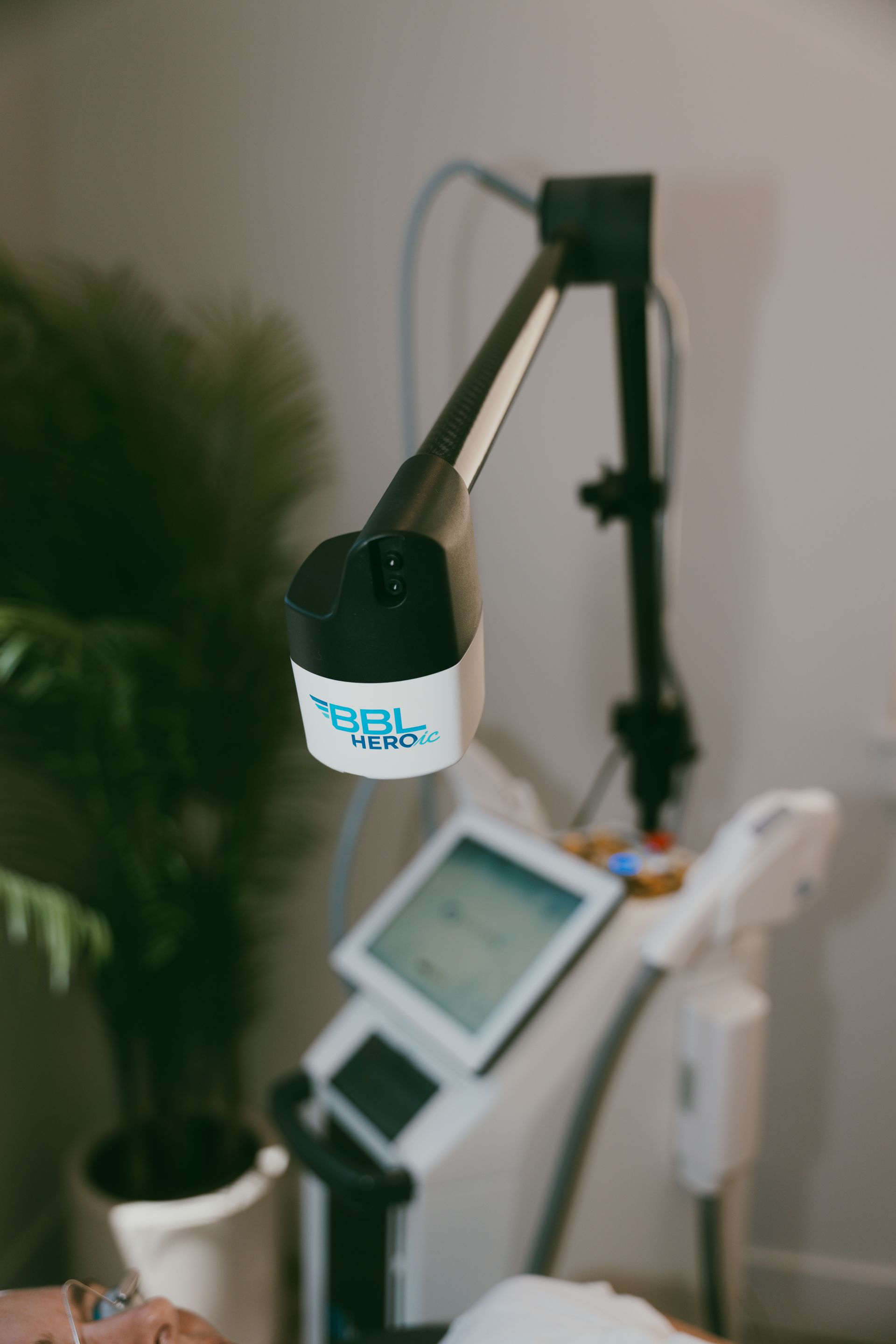 White microphone on a boom arm beside a small tilted monitor in a home studio corner