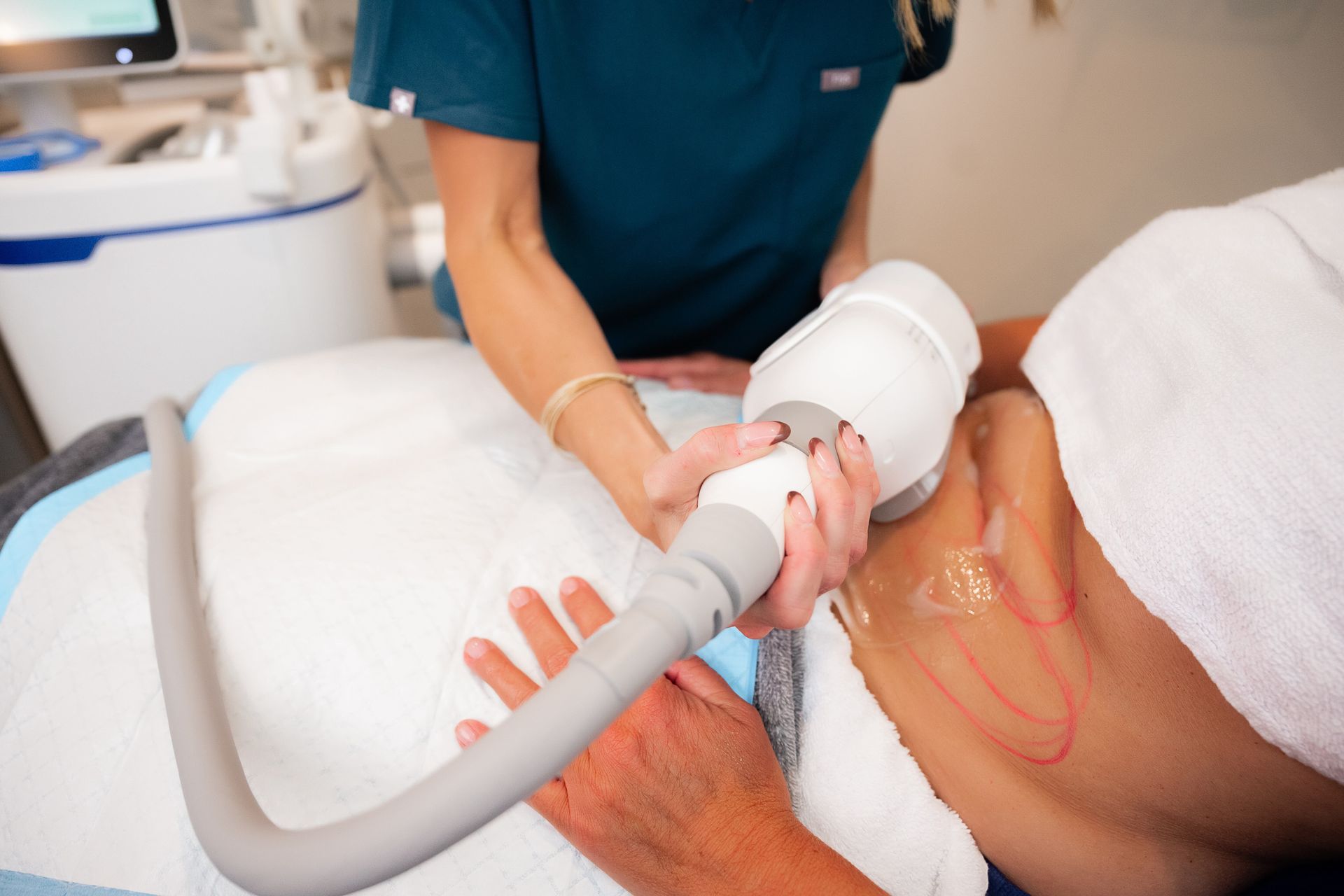 Medical procedure with a technician using a handheld device on a patient's abdomen