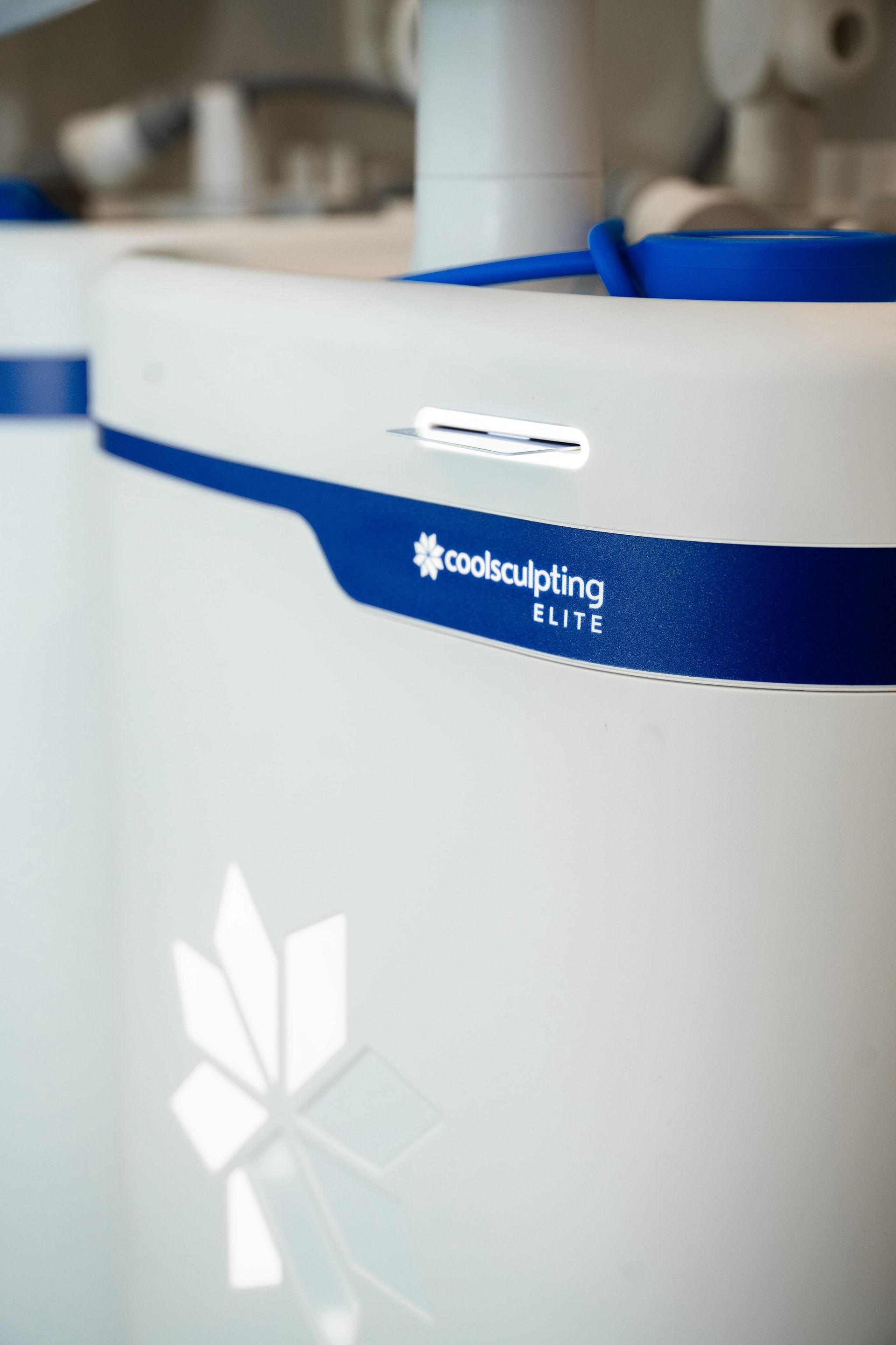 White industrial tank with a blue band and logo, shown in a factory setting