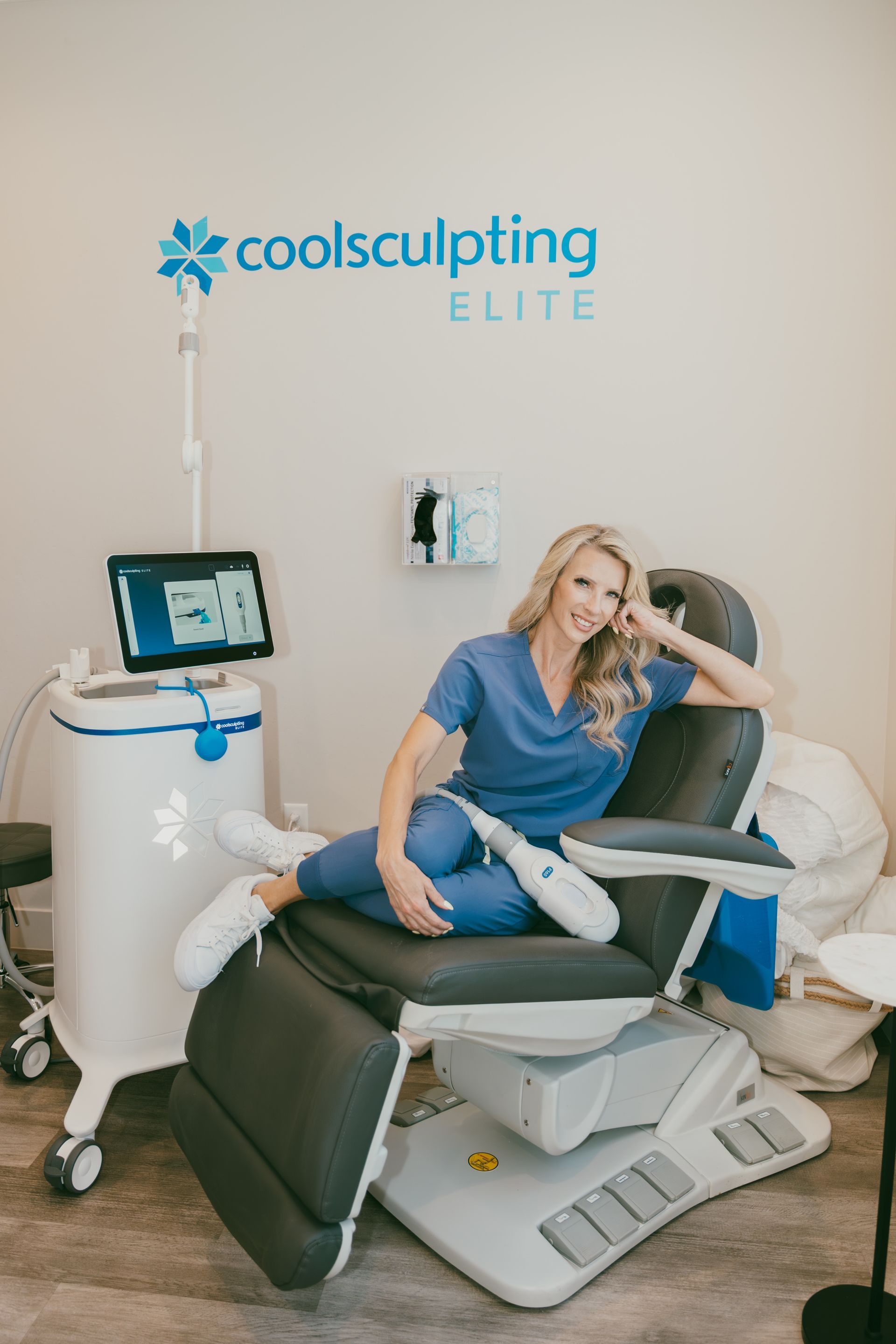 Clinician demonstrating CoolSculpting treatment on a patient in a medical spa room