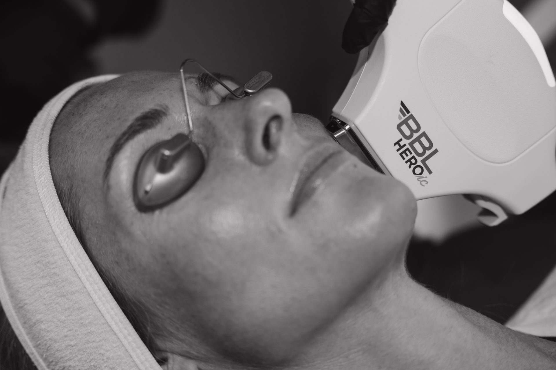 Close-up of a woman using a handheld beauty device on her face