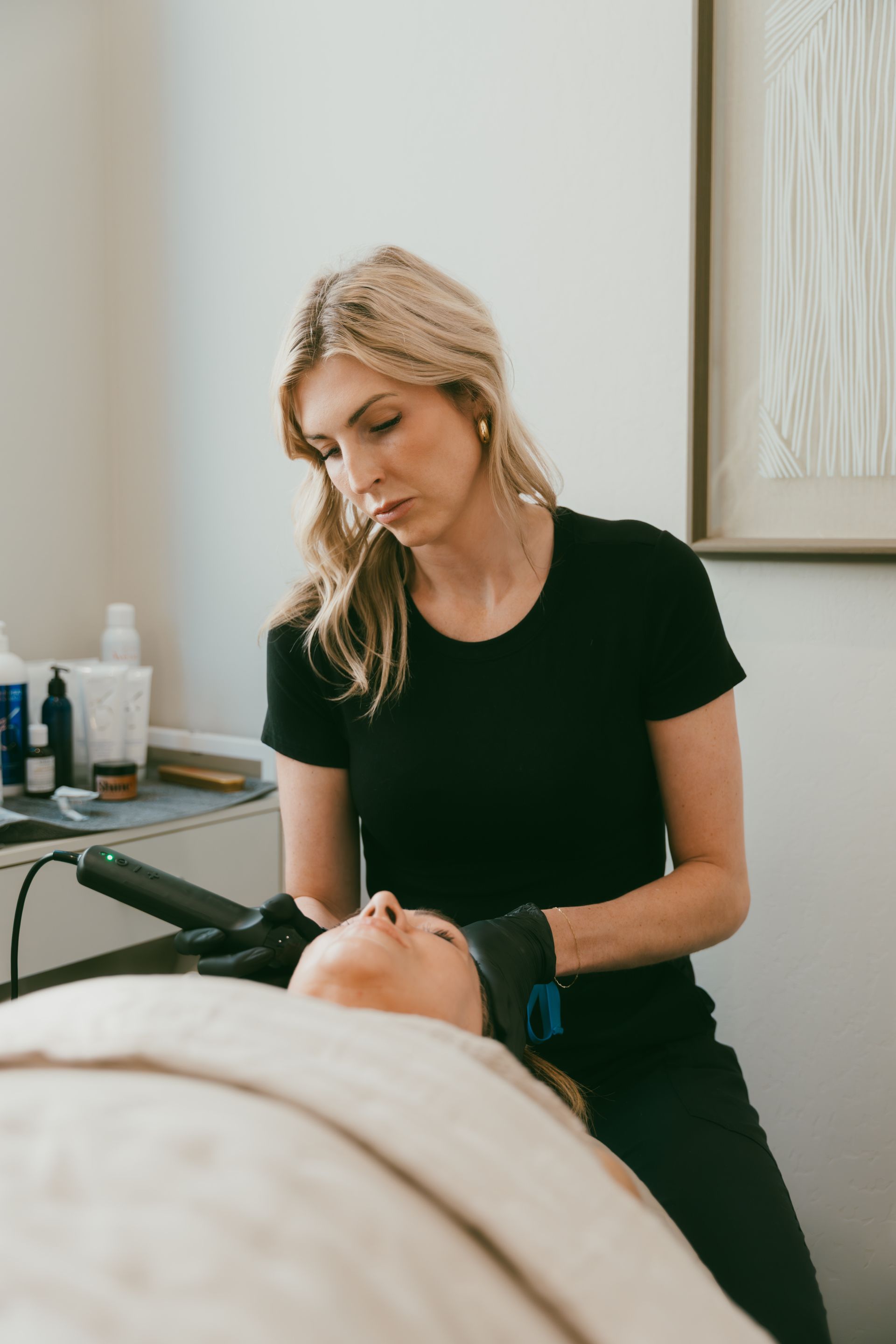 Esthetician performing a facial treatment on a client in a spa room