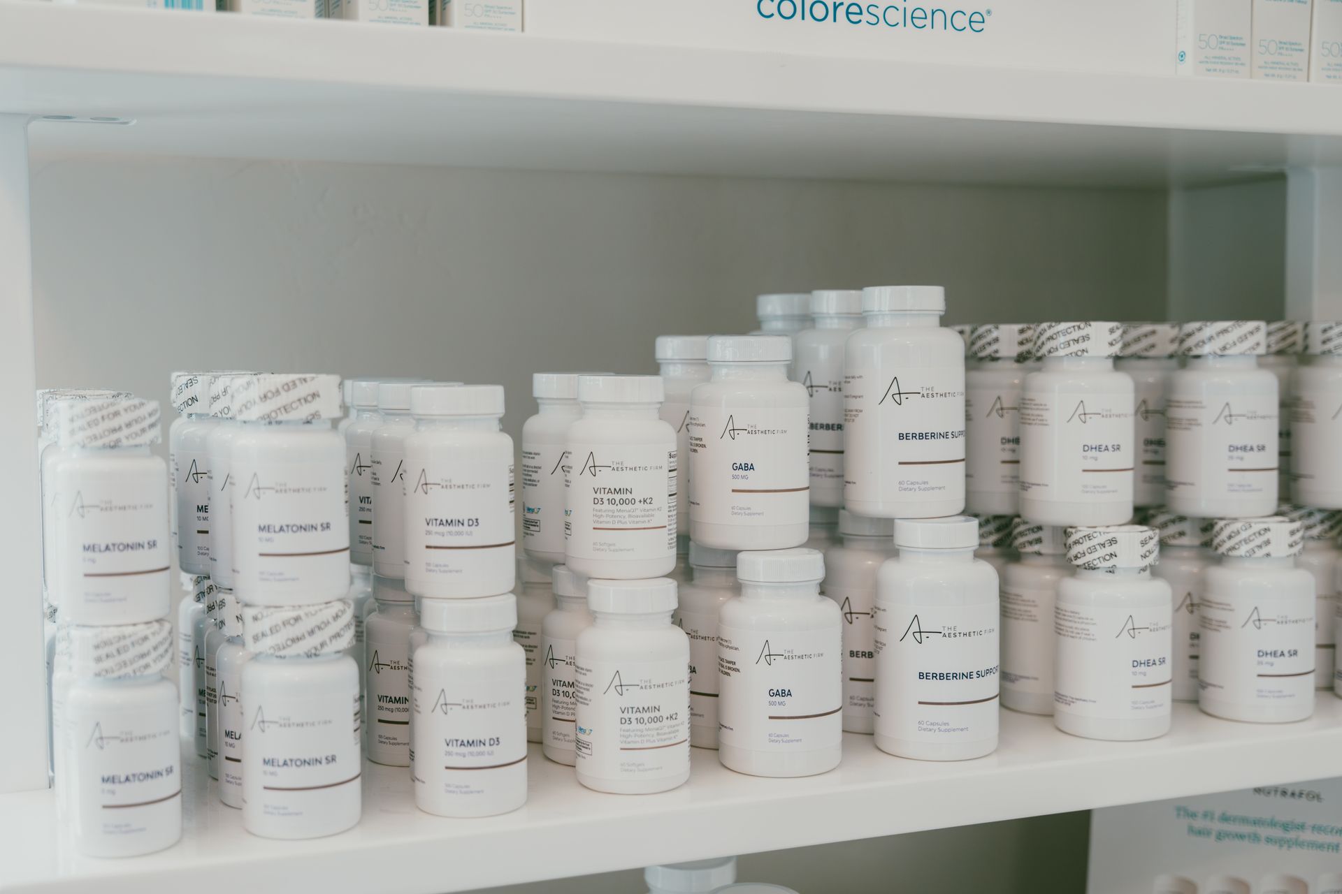 Shelves of neatly stacked white cosmetic jars and bottles in a display cabinet