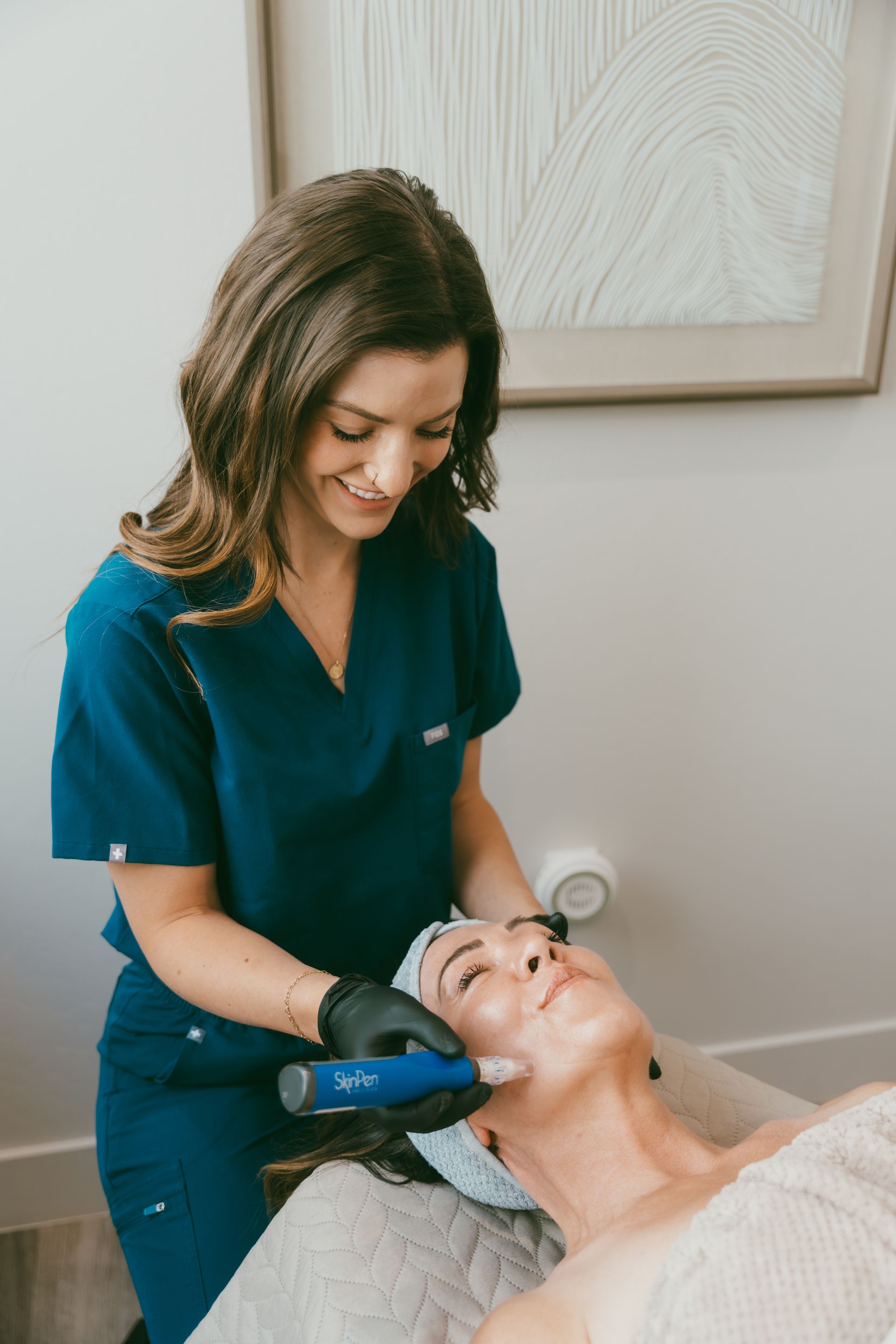 Esthetician performing a facial treatment on a client in a spa room