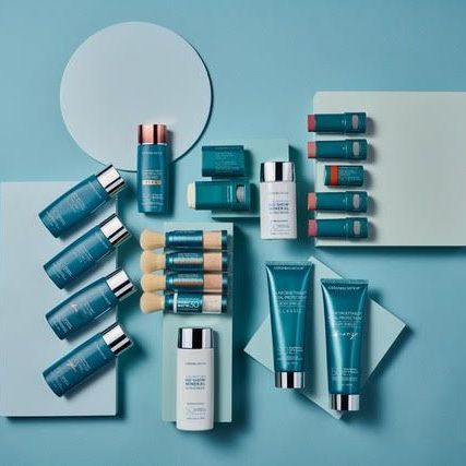Assorted teal and white skincare tubes and bottles arranged neatly on a light blue background