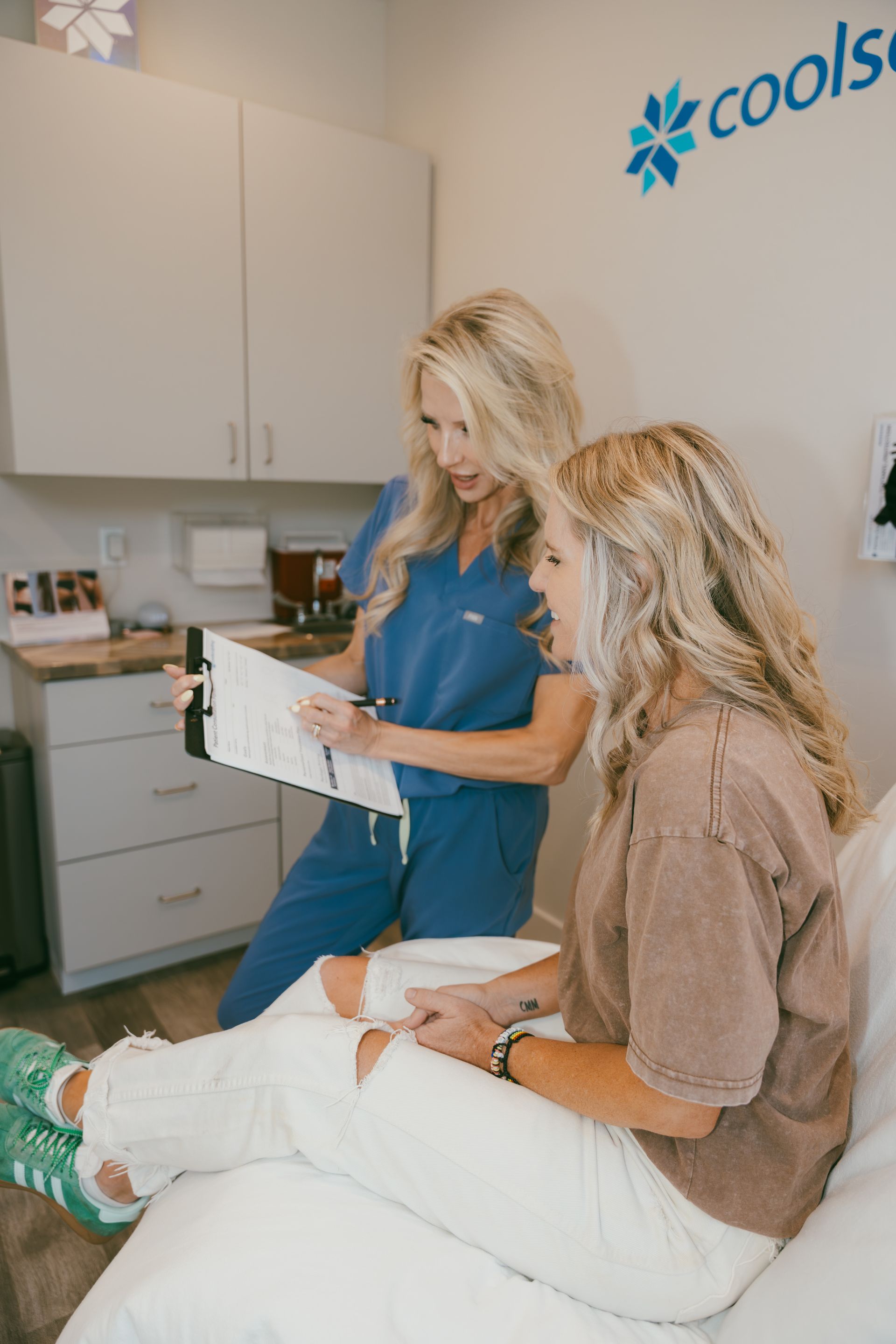 Doctor showing a chart to a seated patient in a clinic office