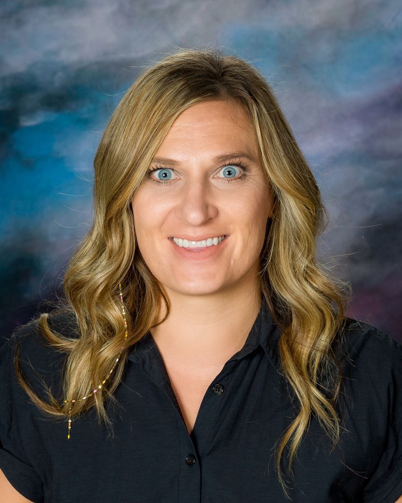 A woman in a black shirt is smiling for the camera.