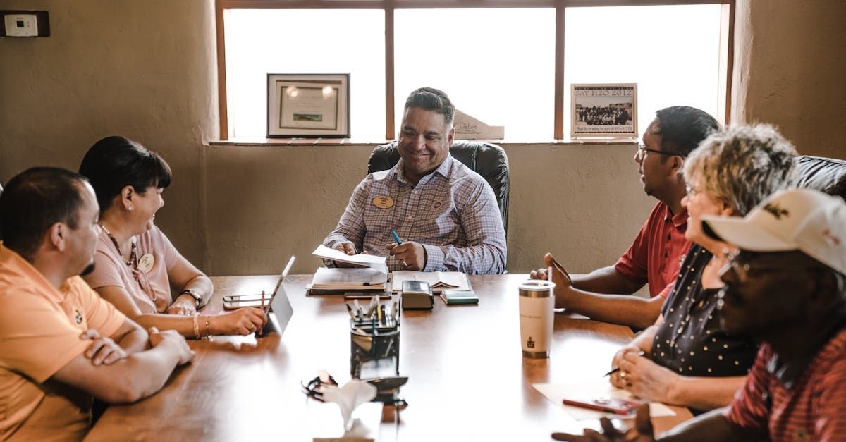 A group of people are sitting around a table having a meeting.