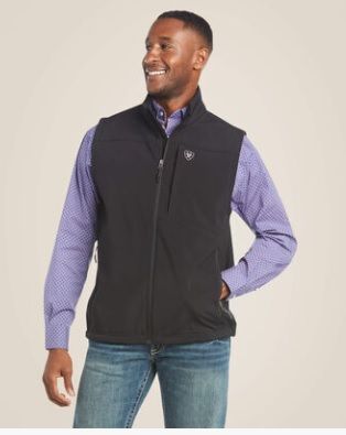 A man is wearing a black vest and a purple shirt.