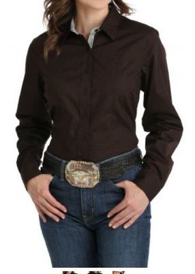 A woman is wearing a brown shirt and blue jeans