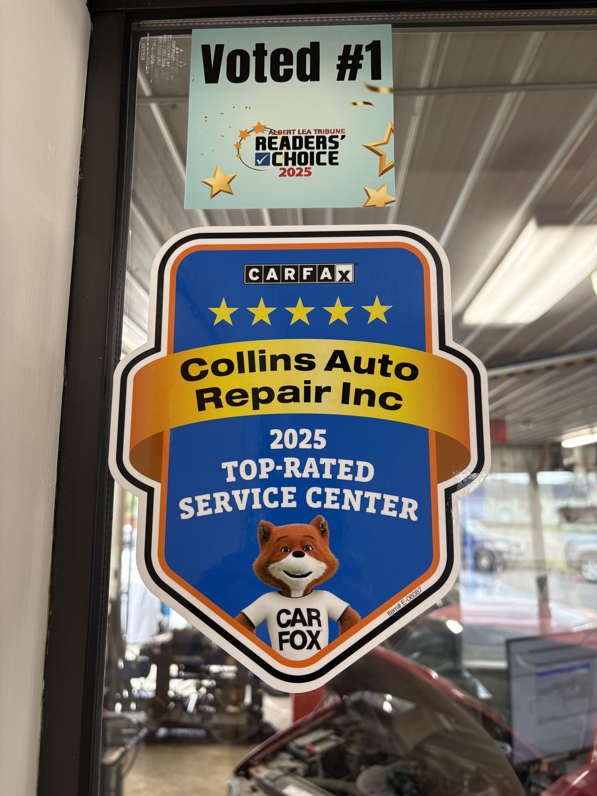 Window decals showing “Voted #1” and a “Collins Auto Repair Inc” 2025 top-rated service center award sticker
