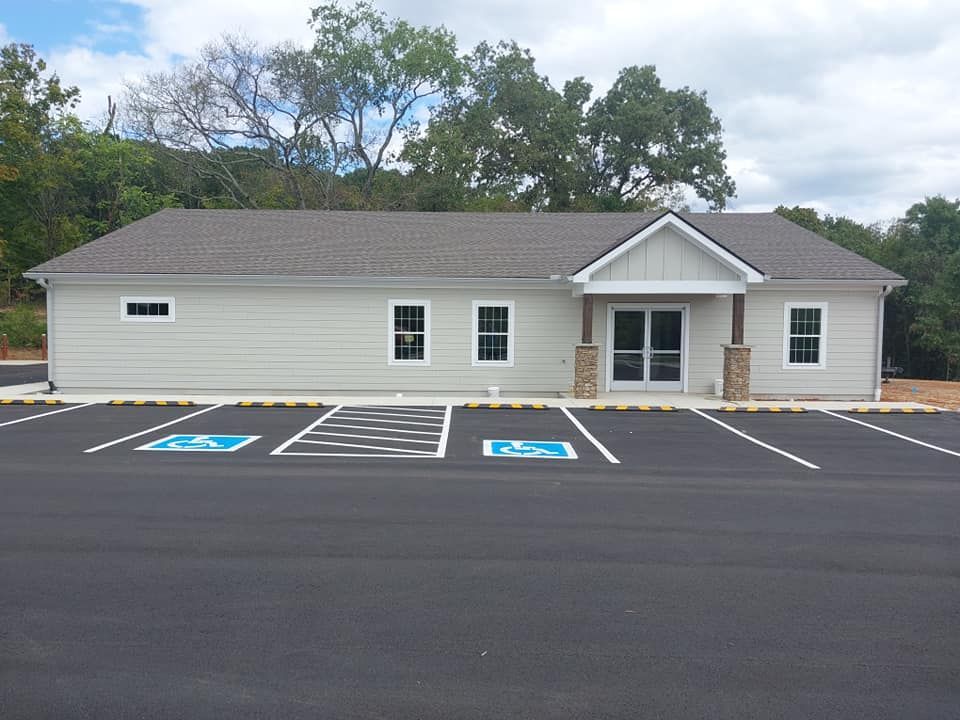 Single-story beige building with parking lot and accessible spaces in front