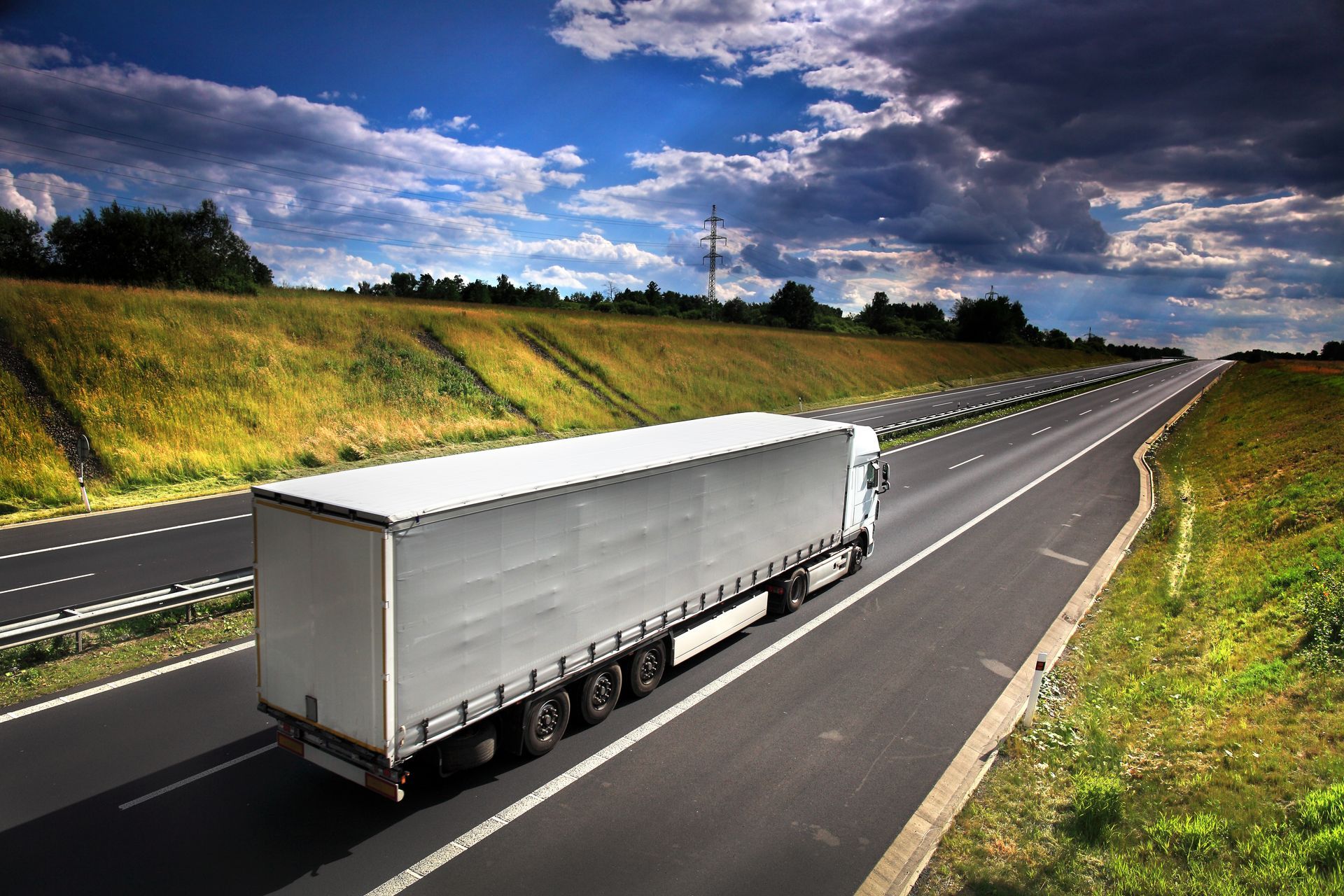 Truck on a road with green pastures surrounding it. Truck on a road with green pastures surrounding it.