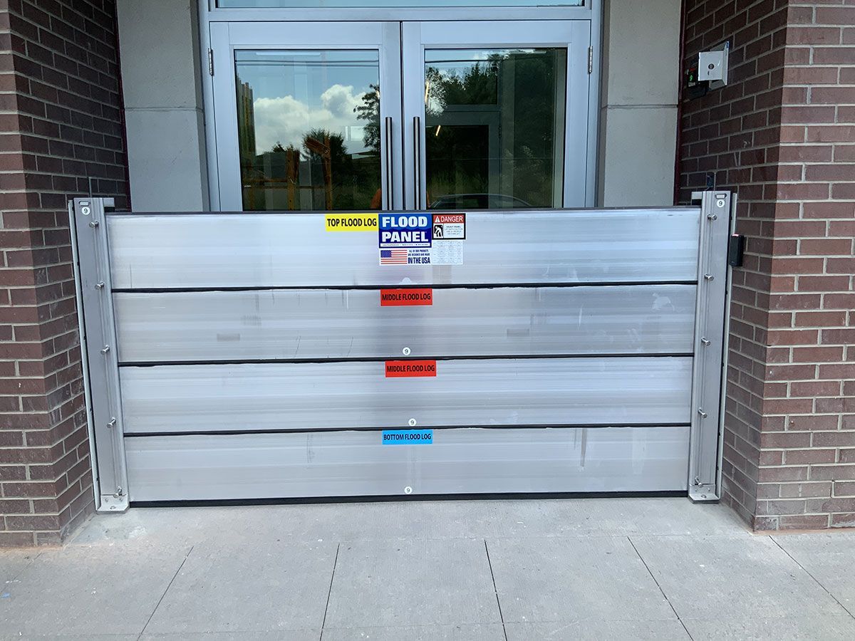 A flood barrier is in front of a brick building