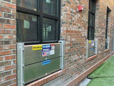 A brick building with a flood panel on the side of it.