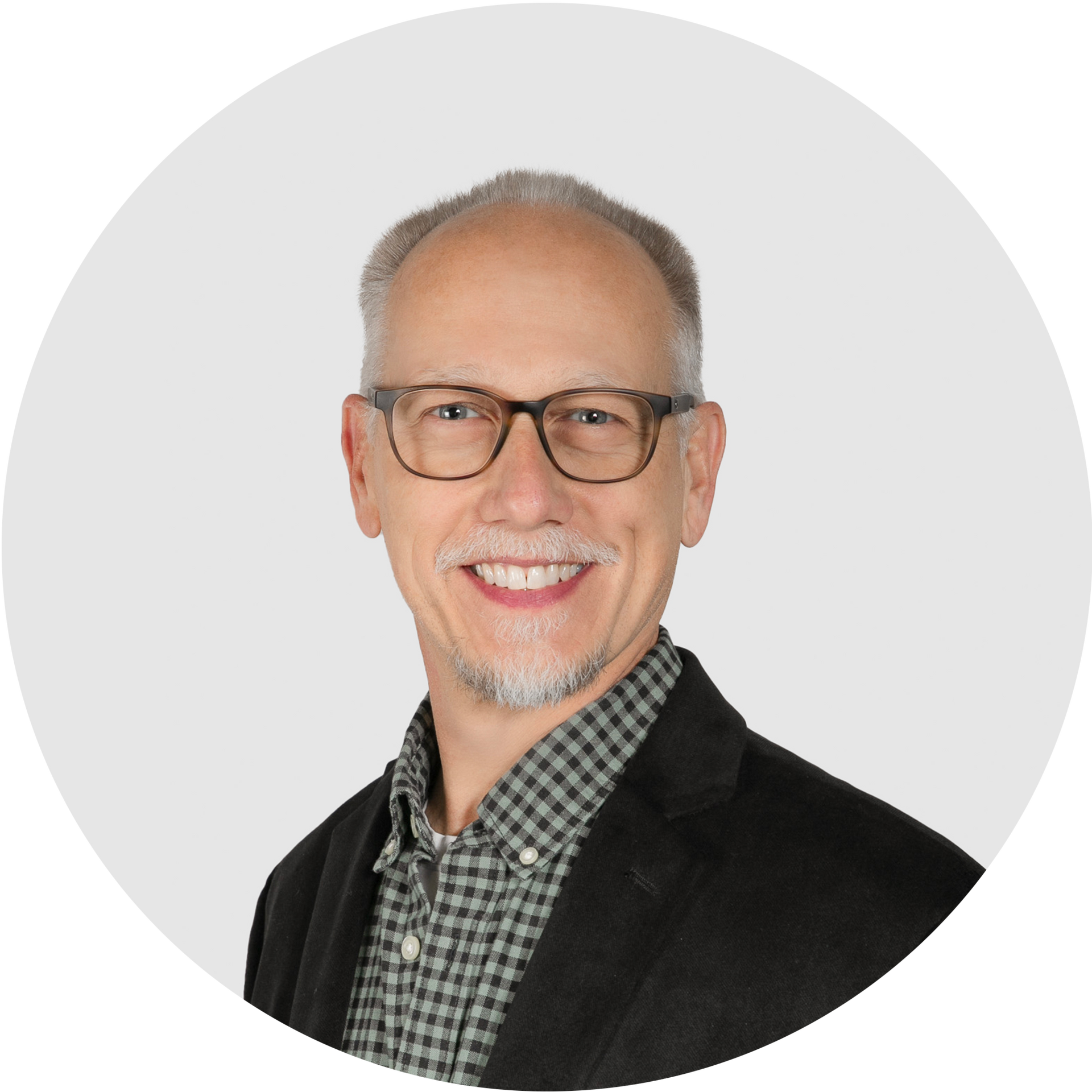 A bald man with a beard wearing sunglasses and a grey shirt.