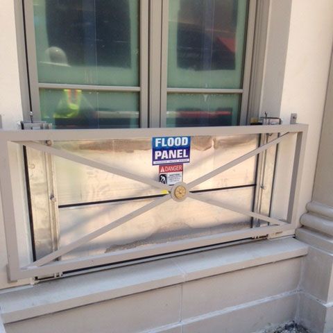A flood panel is sitting on the window sill of a building.