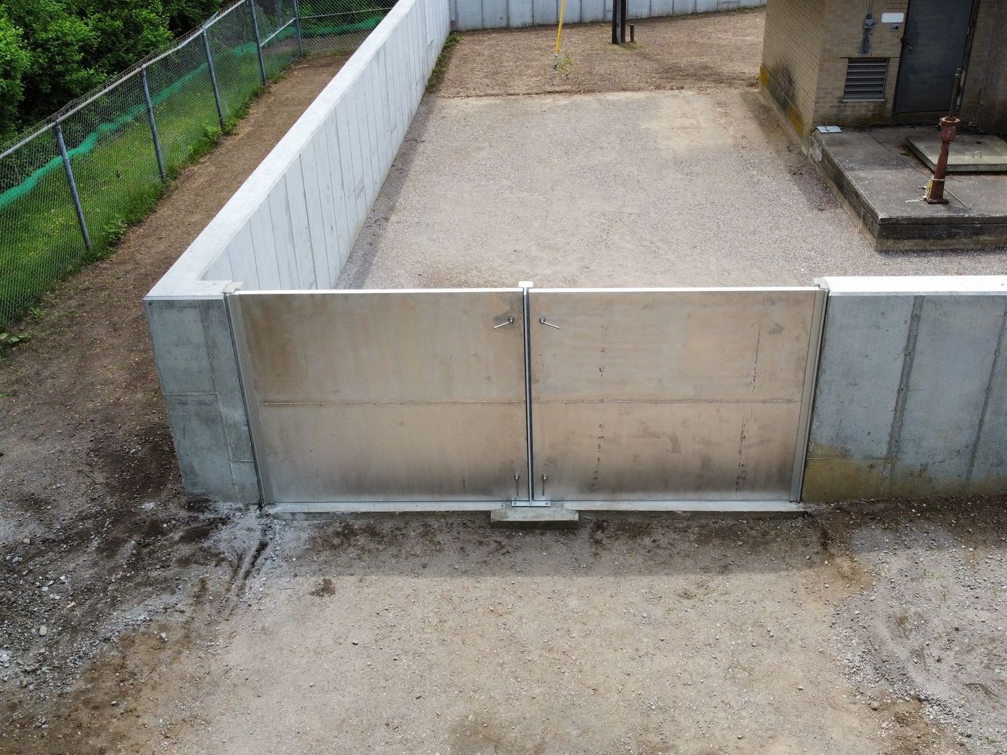 An aerial view of a concrete wall with a metal gate.