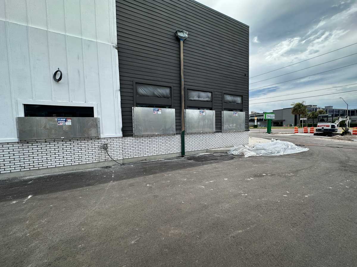 A large building with a lot of windows is sitting next to a parking lot.