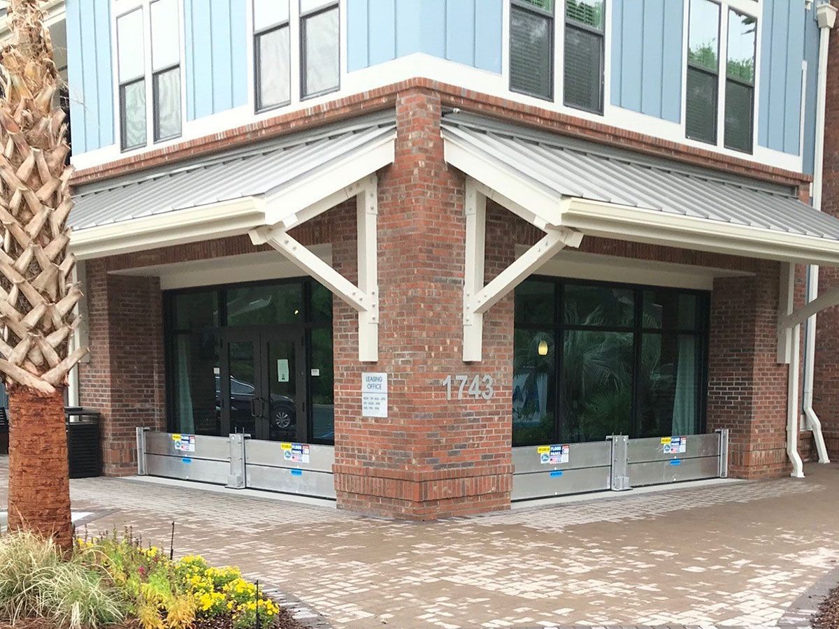 A blue and brick building with flood barriers in front of it.