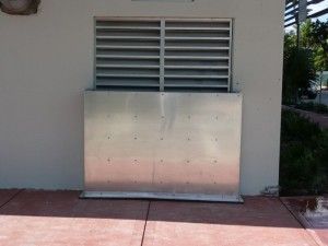 A metal box is sitting on the side of a building.