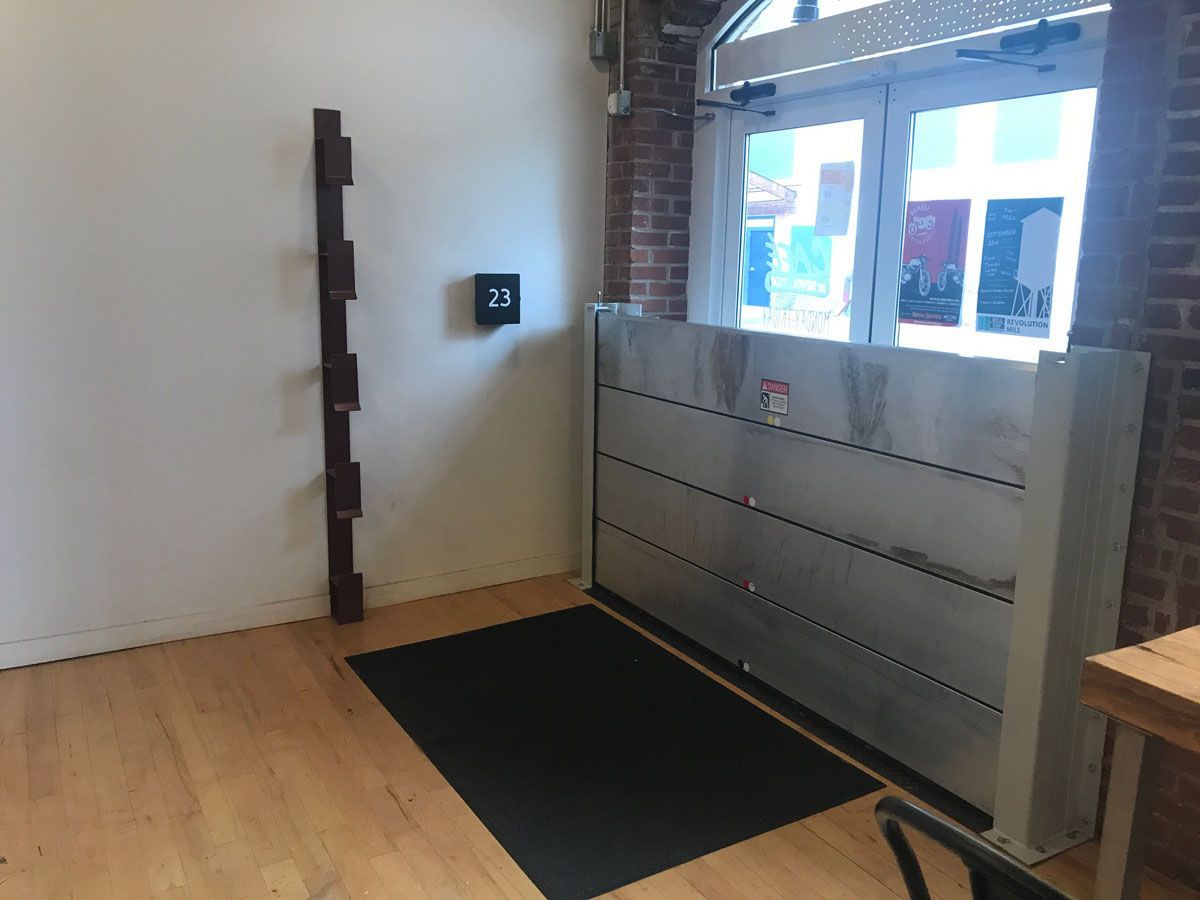 A room with a wooden floor and a flood barrier in front of a door.