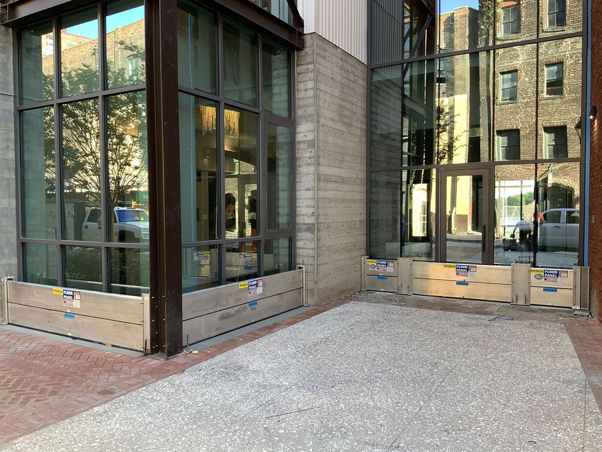A large building with a lot of windows and a sidewalk in front of it.