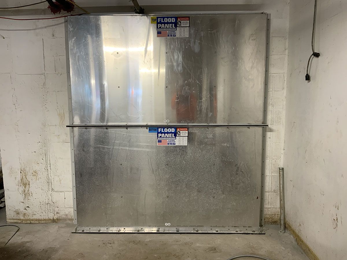 Two metal boxes are stacked on top of each other in a garage.