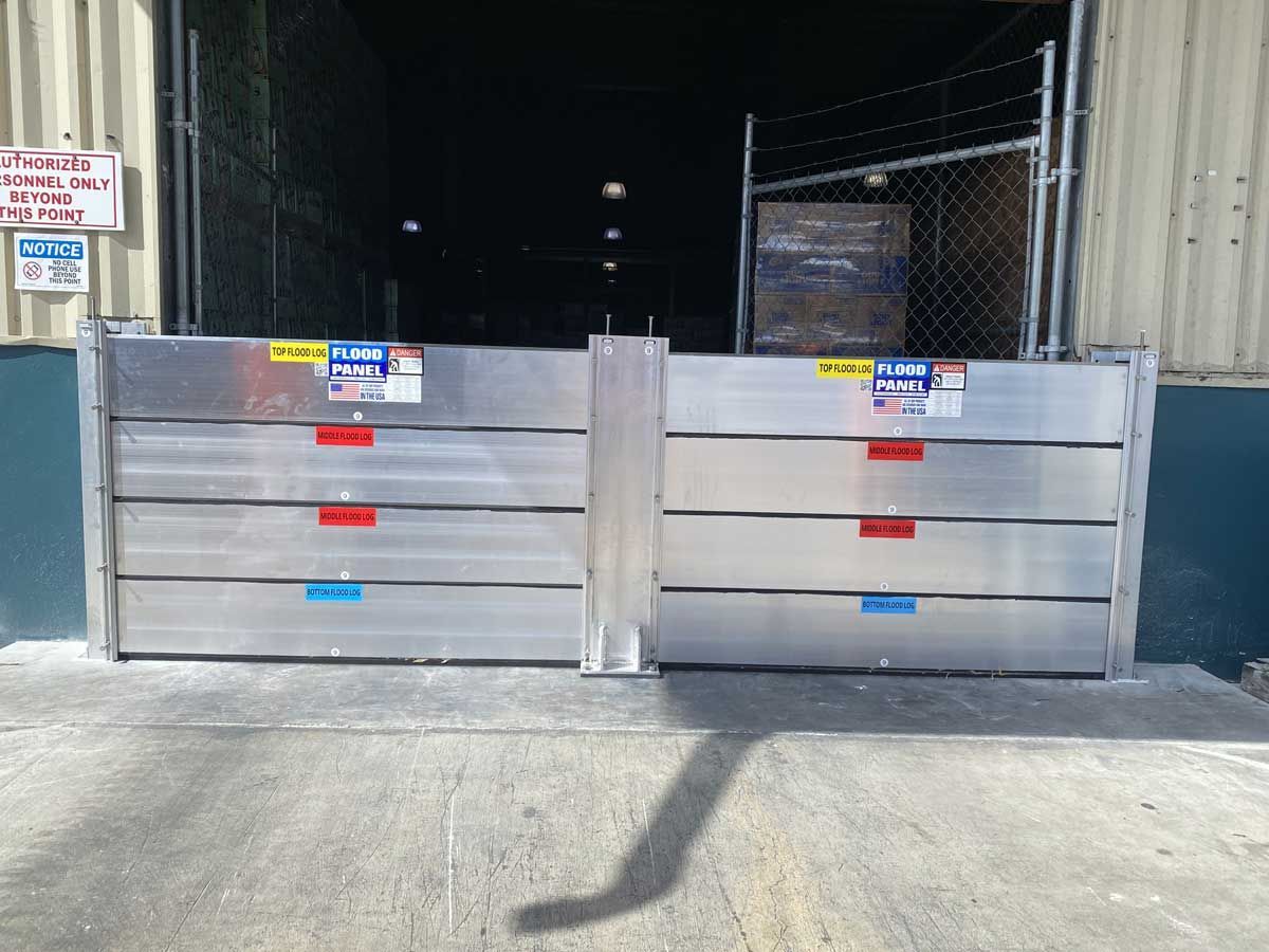 A pair of aluminum flood barriers are in front of a building.