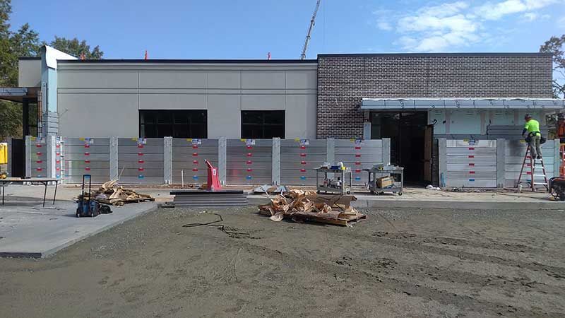 A large building is being built with a lot of concrete in front of it.