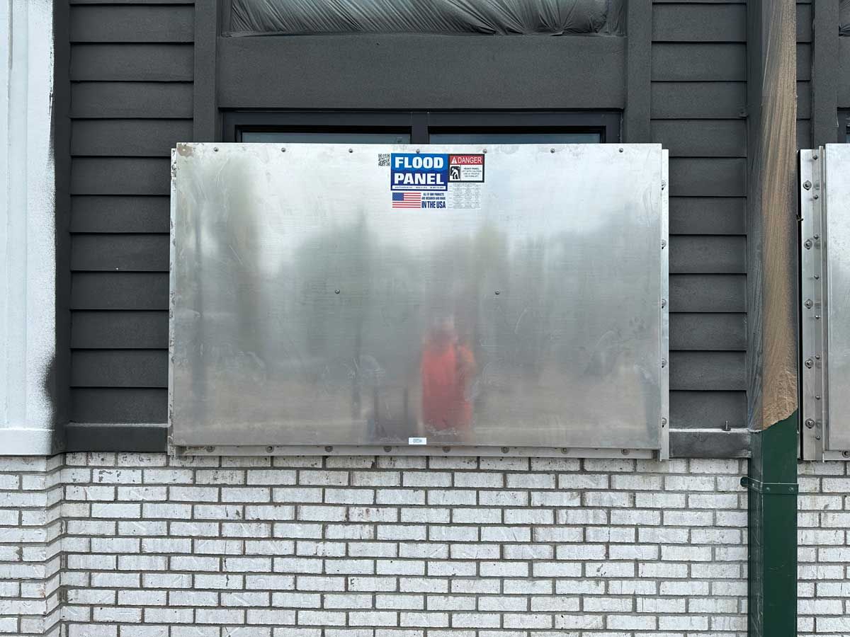 A brick wall with a metal box on it.