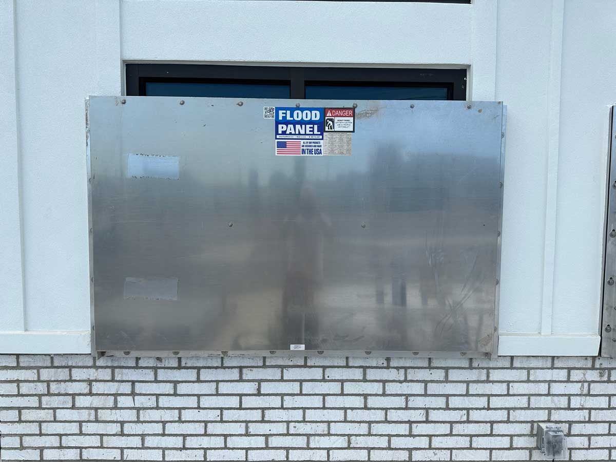 A brick wall with a stainless steel panel on it.