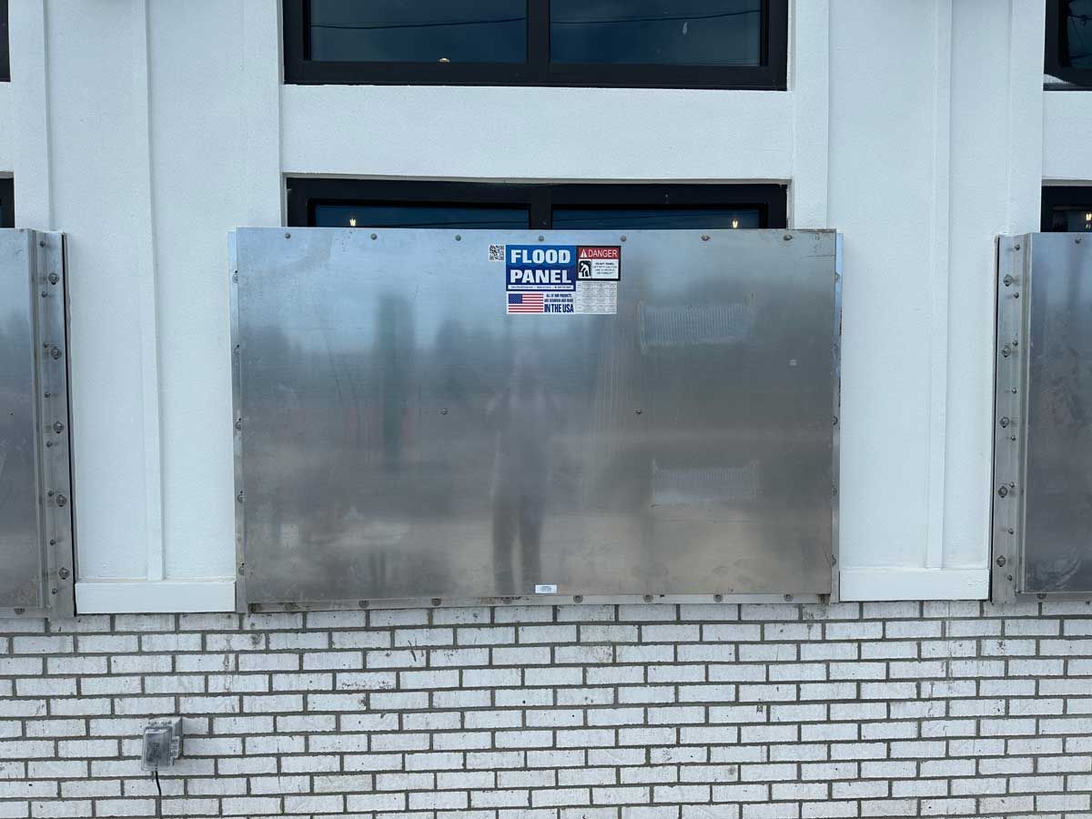 A brick wall with a stainless steel barrier on it.
