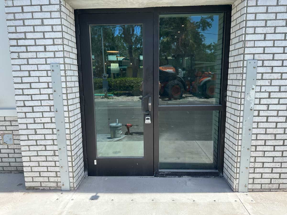 A brick building with a glass door and a tractor behind it