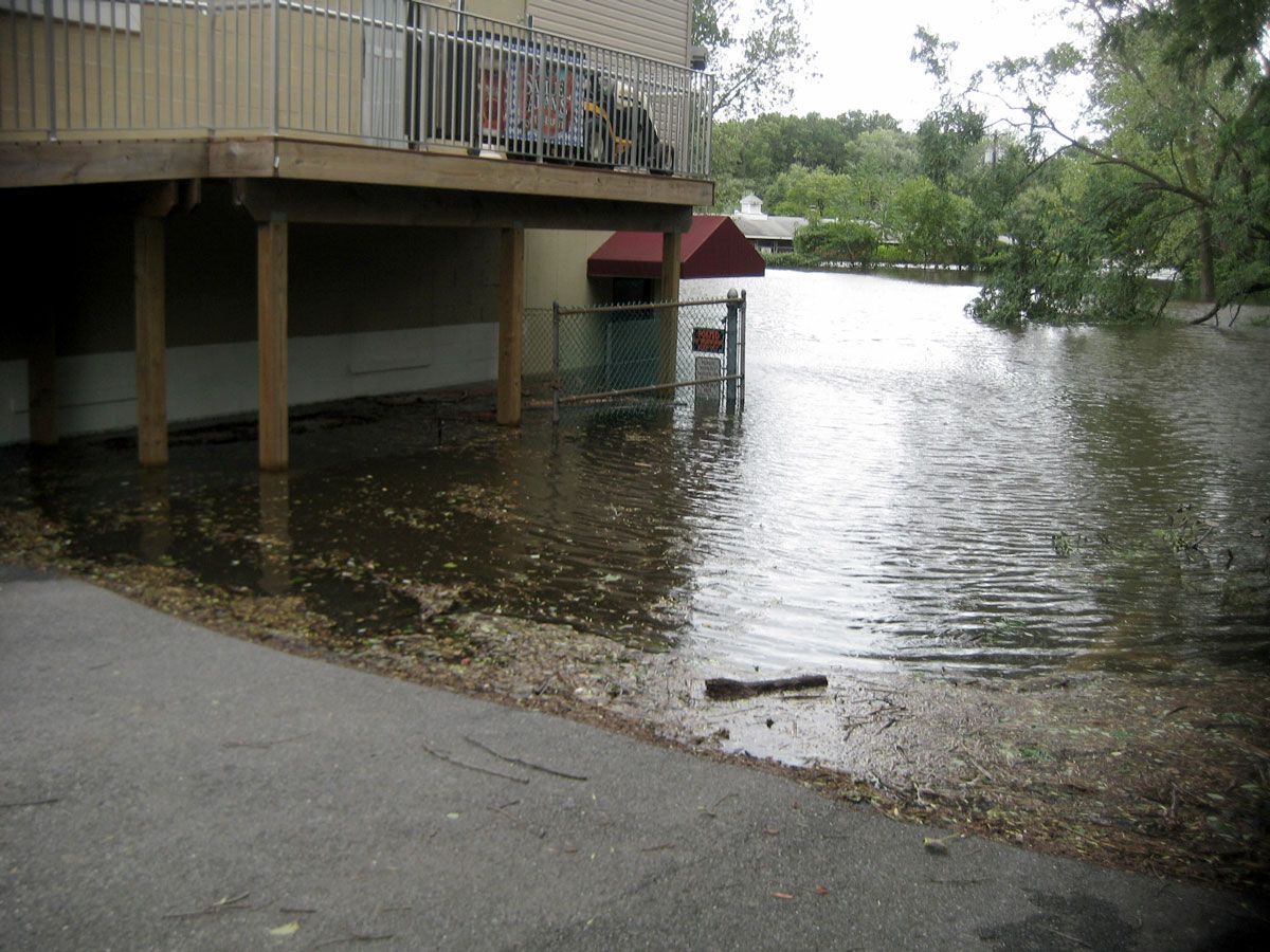 A flooded area with a house in the background